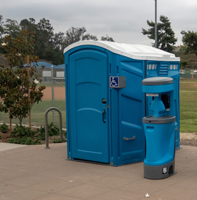 ada wheelchair accessible porta potty near a baseball field