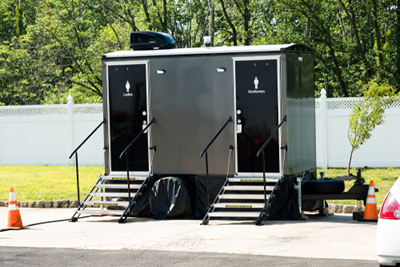 deluxe portable toilet at an outdoor venue near a fence