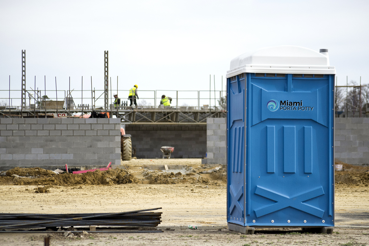 miami porta potty unit on a construction site with workers